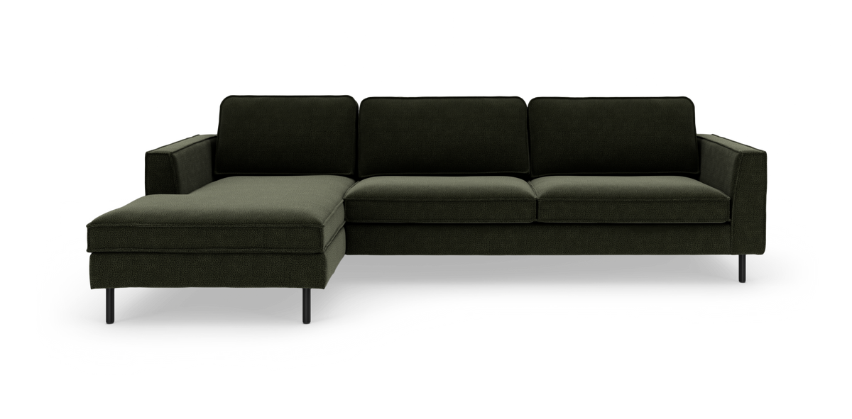 Mørkegrøn modulsofa med venstrevendt chaiselong og slanke sorte ben, set forfra.