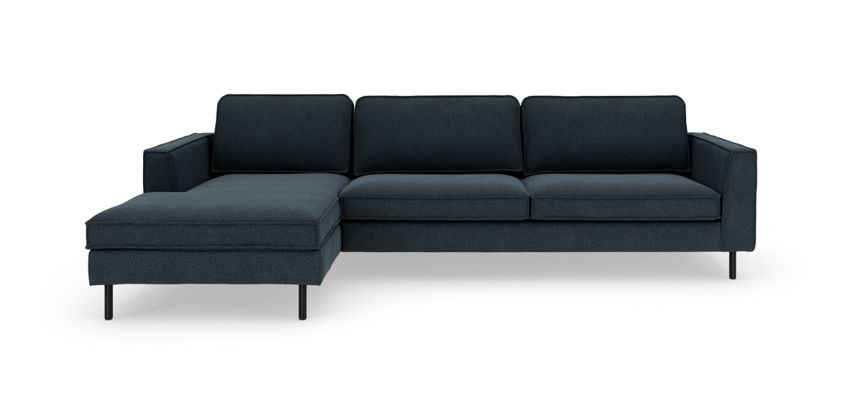 Mørkeblå hjørnesofa med venstrevendt chaiselong og slanke sorte ben i minimalistisk design.