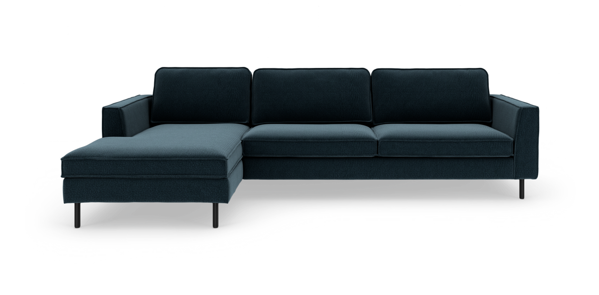 Mørk petrolblå hjørnesofa med venstre chaiselong og slanke sorte ben, frilagt på hvid baggrund.