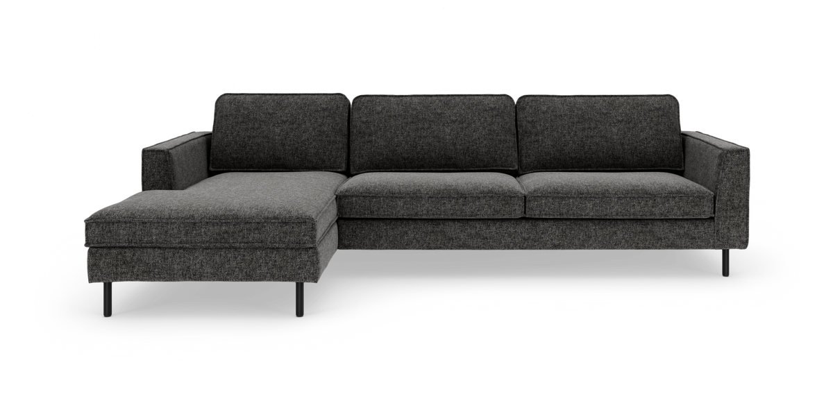 Mørkegrå modulsofa med venstre chaiselong på slanke sorte ben, frilagt på hvid baggrund.
