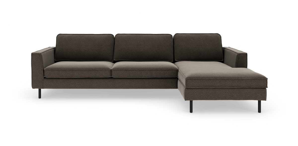 Mørkegrå hjørnesofa med chaiselong til højre, rene linjer og slanke sorte ben, frilagt på hvid baggrund.