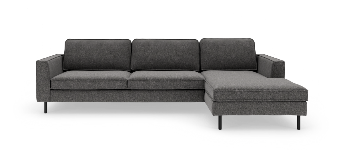Mørkegrå hjørnesofa med chaiselong til højre og slanke sorte ben, fritlagt på hvid baggrund.