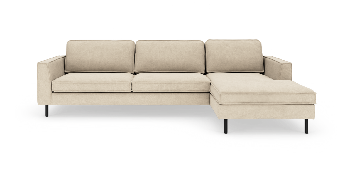 Beige modulsofa med chaiselong i højre side og slanke sorte ben, frontvisning på hvid baggrund.