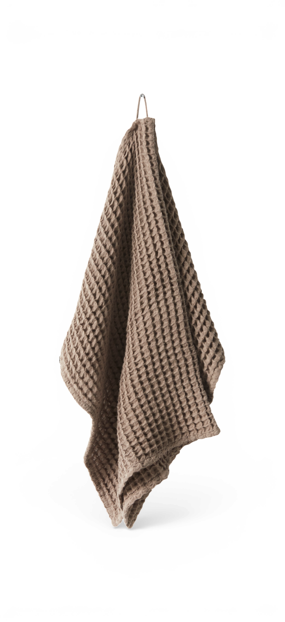 Beige vaffelvævet håndklæde hængt på krog.