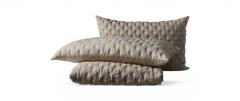 Beige quiltet sengesæt med to puder og sammenfoldet dyne i struktureret diamantmønster.