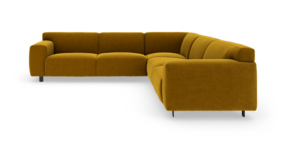 Sennepsgul L-formet modulsofa med lave armlæn og metalben, fritlagt i studie.