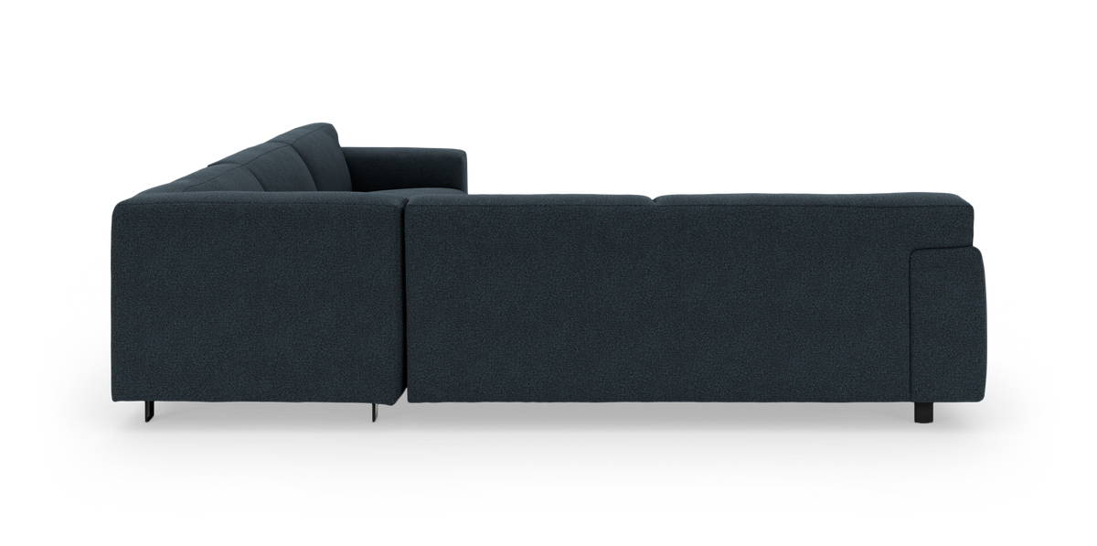 Mørkeblå L-formet modulsofa set bagfra på hvid baggrund med lave sorte ben.