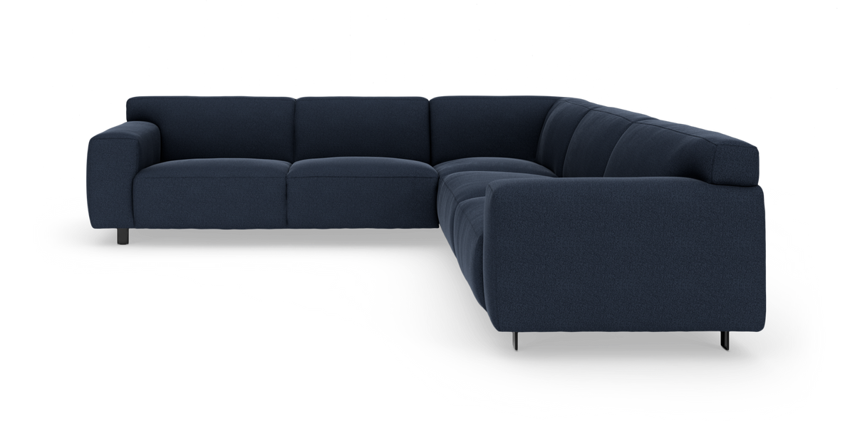 Mørkeblå L-formet modulsofa med kraftige armlæn og metalben på hvid baggrund.