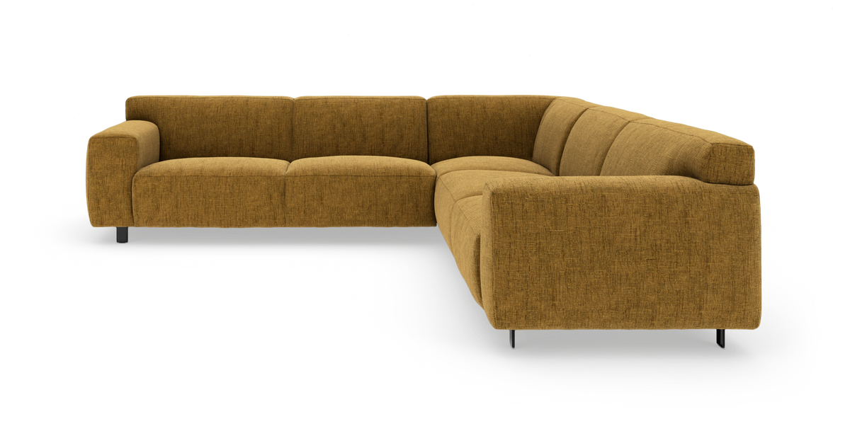 Modulær L-sofa i sennepsgul tekstil med bløde, afrundede former og metalben, fritlagt på hvid baggrund.