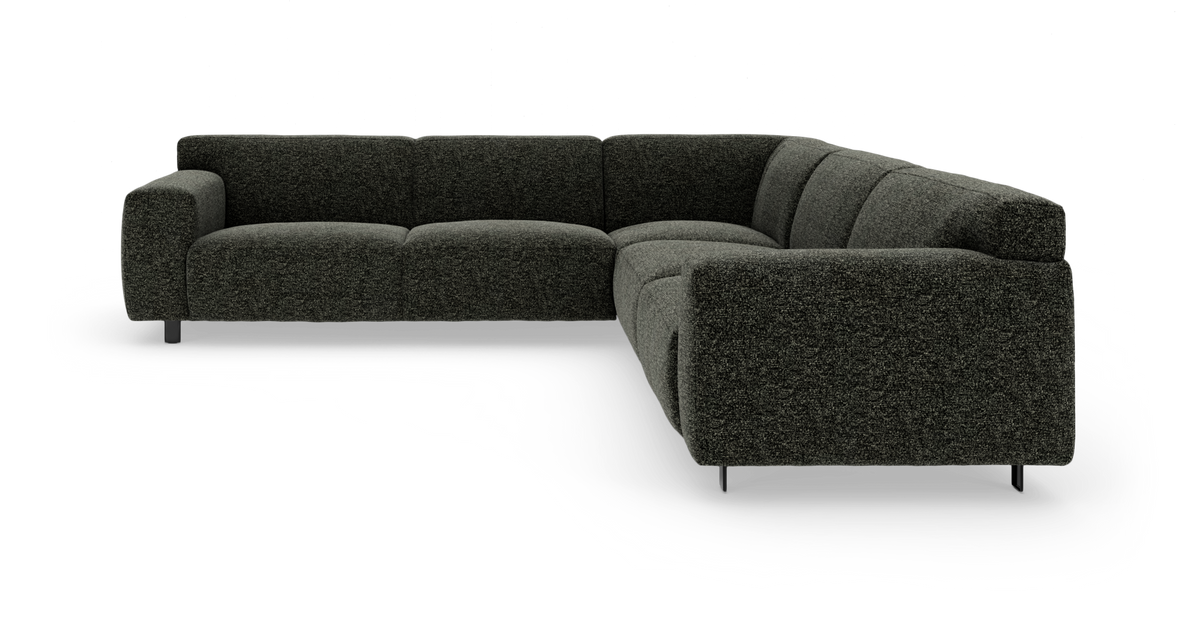 Mørkegrå L-formet modulsofa i tekstil med bløde, brede puder og metalben, frilagt på hvid baggrund.