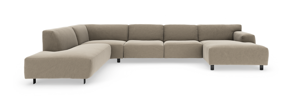 L-formet modulsofa i beige stof med slanke sorte ben, frilagt på hvid baggrund.