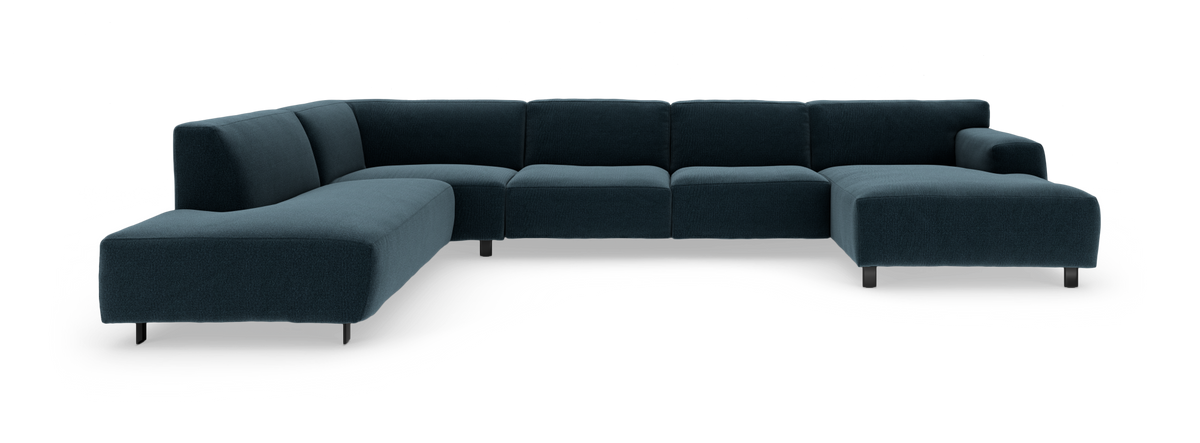 Modulær L‑formet hjørnesofa i mørkt petroleumsblåt stof med slanke sorte ben, fritstående på hvid baggrund.