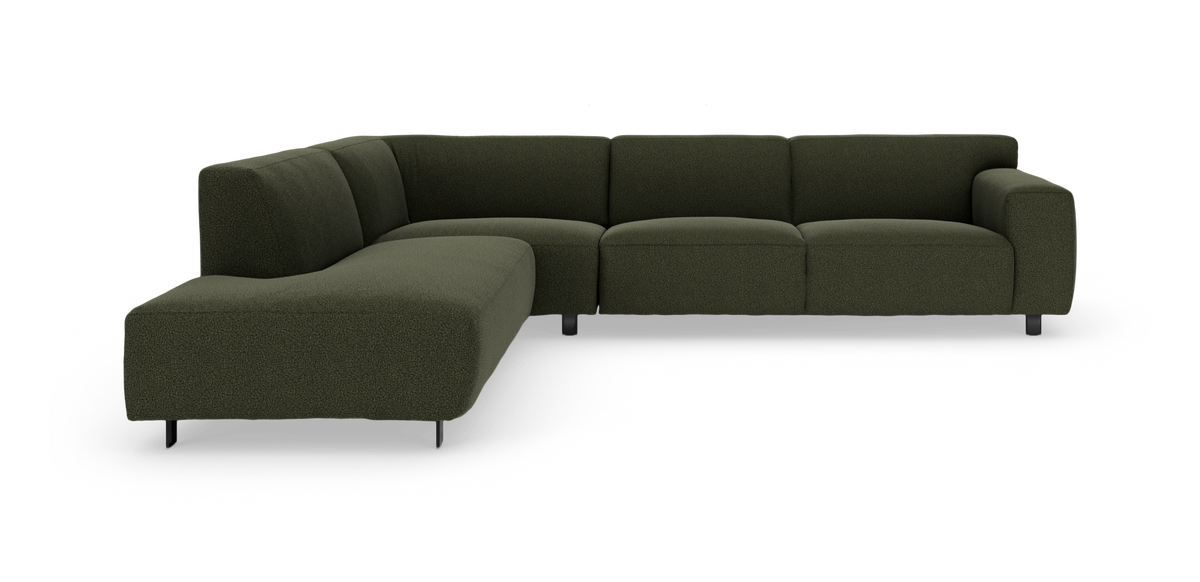 Mørkegrøn modulsofa i L‑form med chaiselong til venstre, vist mod hvid studiebaggrund.
