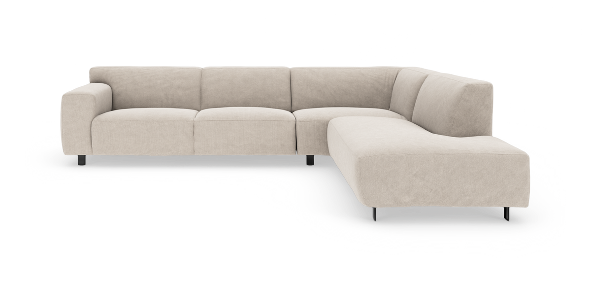 Beige L‑sofa med chaiselong til højre, riflet stofpolstring og sorte metalben, frilagt på hvid baggrund.
