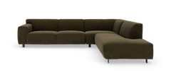 Modulær L‑formet hjørnesofa i mørk olivgrøn fløjl med slanke metalben, set forfra i studie.