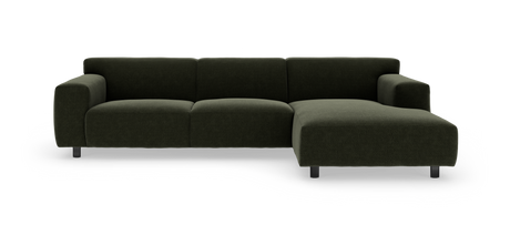 Mørkegrøn modulsofa med chaiselong til højre på hvid baggrund.