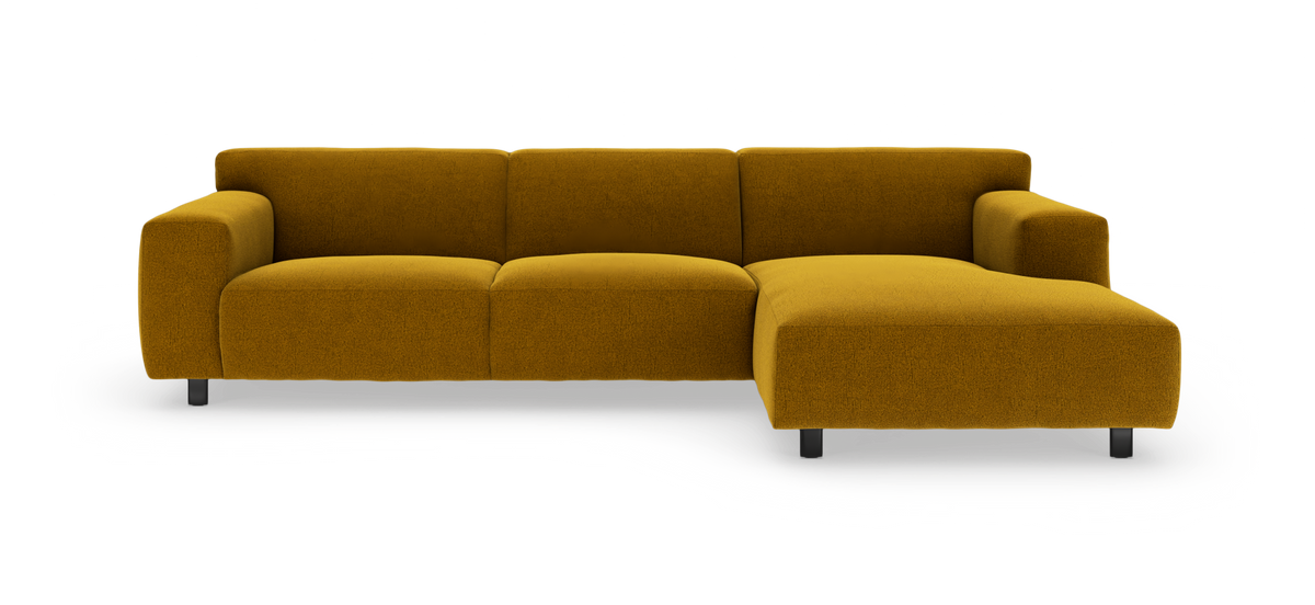 Sennepsgul modulsofa med chaiselong til højre, bløde puder og metalben, frilagt på hvid baggrund.