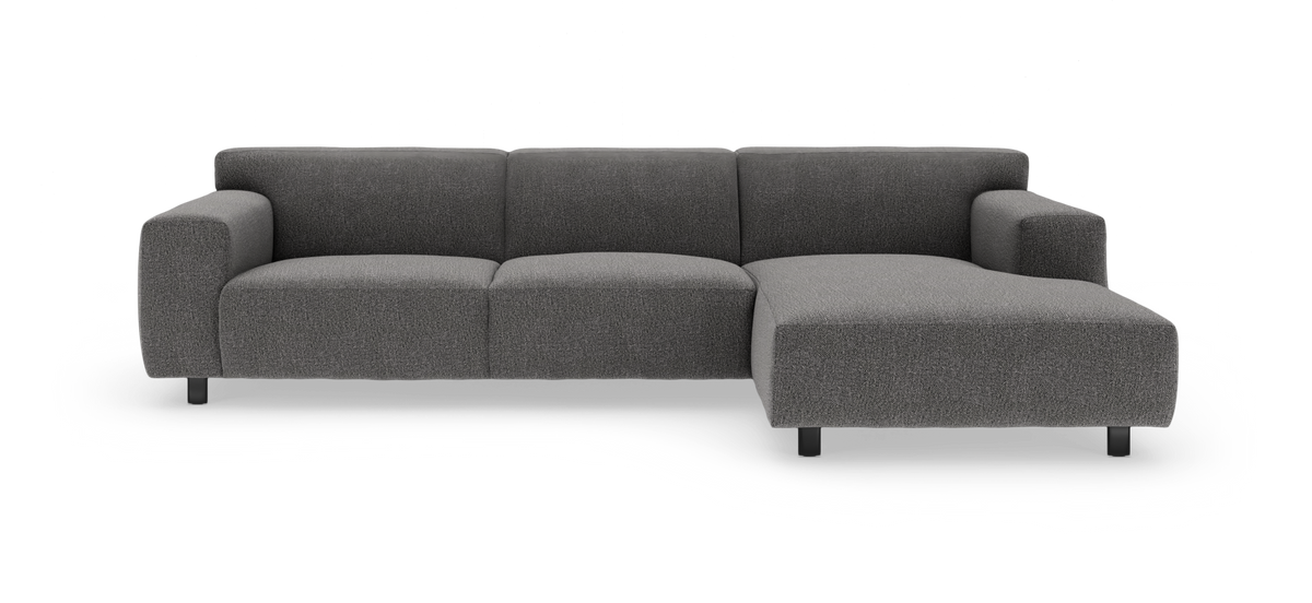 Mørkegrå modulsofa med højre chaiselong i studiemiljø.