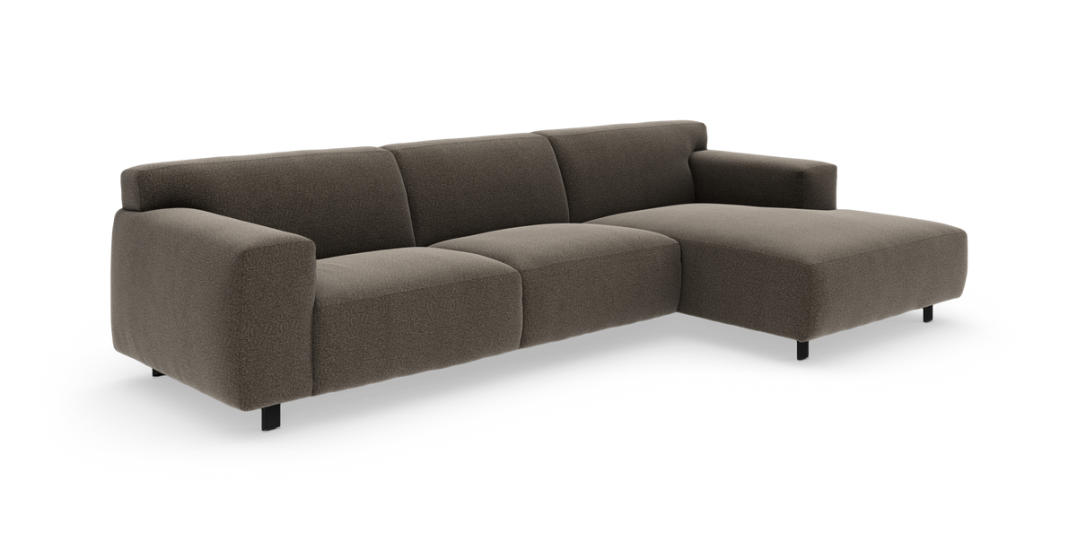 Brun moderne modulsofa i stof med chaiselong til højre, lav profil og afrundede armlæn, frilagt på hvid baggrund.
