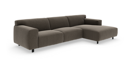 Brun moderne modulsofa i stof med chaiselong til højre, lav profil og afrundede armlæn, frilagt på hvid baggrund.