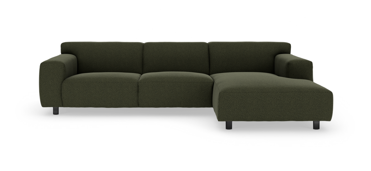 Mørkegrøn modulsofa med chaiselong til højre, afrundede sæder og korte metalben, frilagt på hvid baggrund.