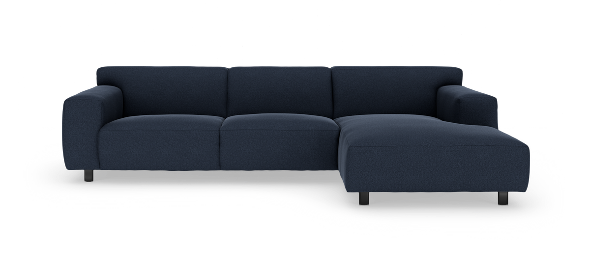 Mørkeblå hjørnesofa med højre chaiselong, fotograferet forfra i studie.