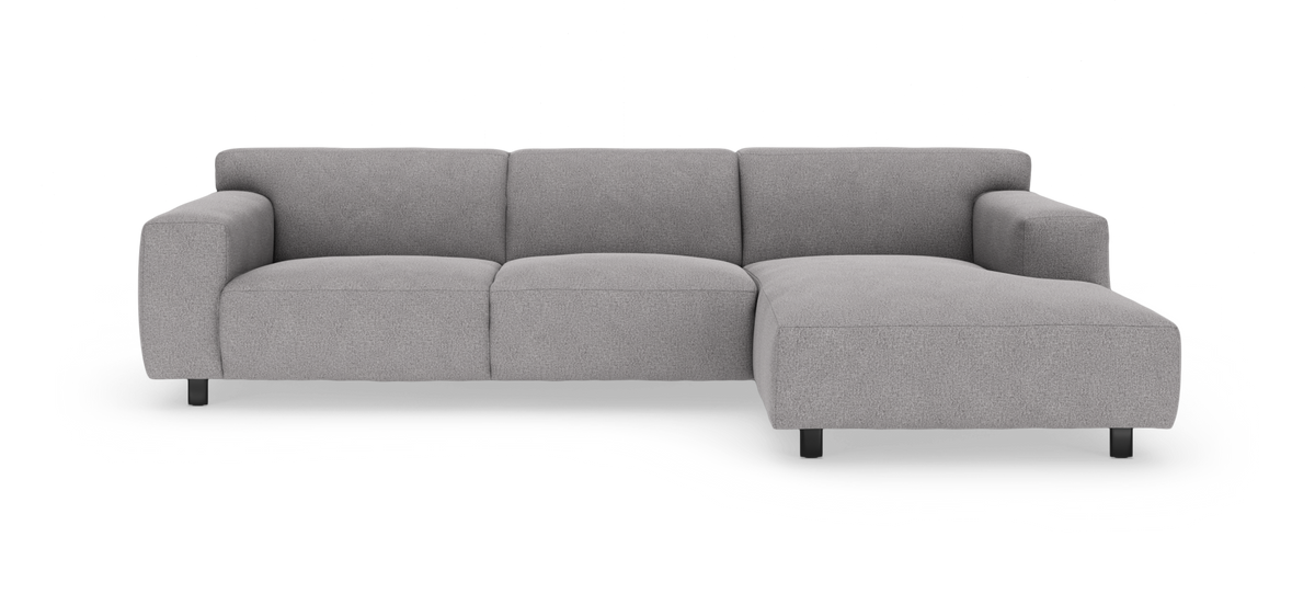 Grå L‑formet modulsofa med højrevendt chaiselong, set forfra på hvid baggrund.