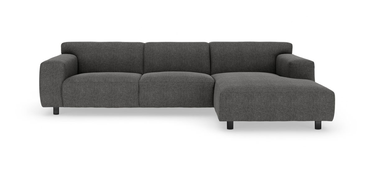 Mørkegrå modulsofa med chaiselong til højre på hvid baggrund.