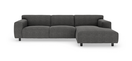 Mørkegrå modulsofa med chaiselong til højre på hvid baggrund.