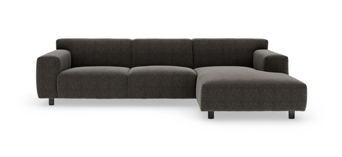 Mørkegrå modulsofa med højrevendt chaiselong, set forfra mod hvid baggrund.