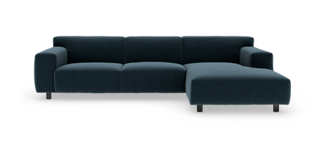 Mørk petrolblå hjørnesofa med chaiselong til højre, på metalben mod hvid studiobaggrund.