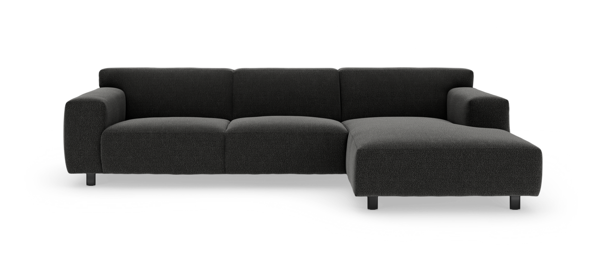 Mørkegrå modulsofa med chaiselong til højre, set forfra mod hvid baggrund.
