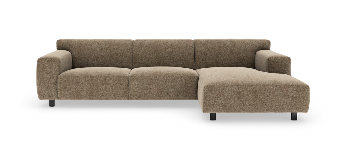 Brun hjørnesofa med chaiselong til højre i blødt, afrundet design på sorte ben.