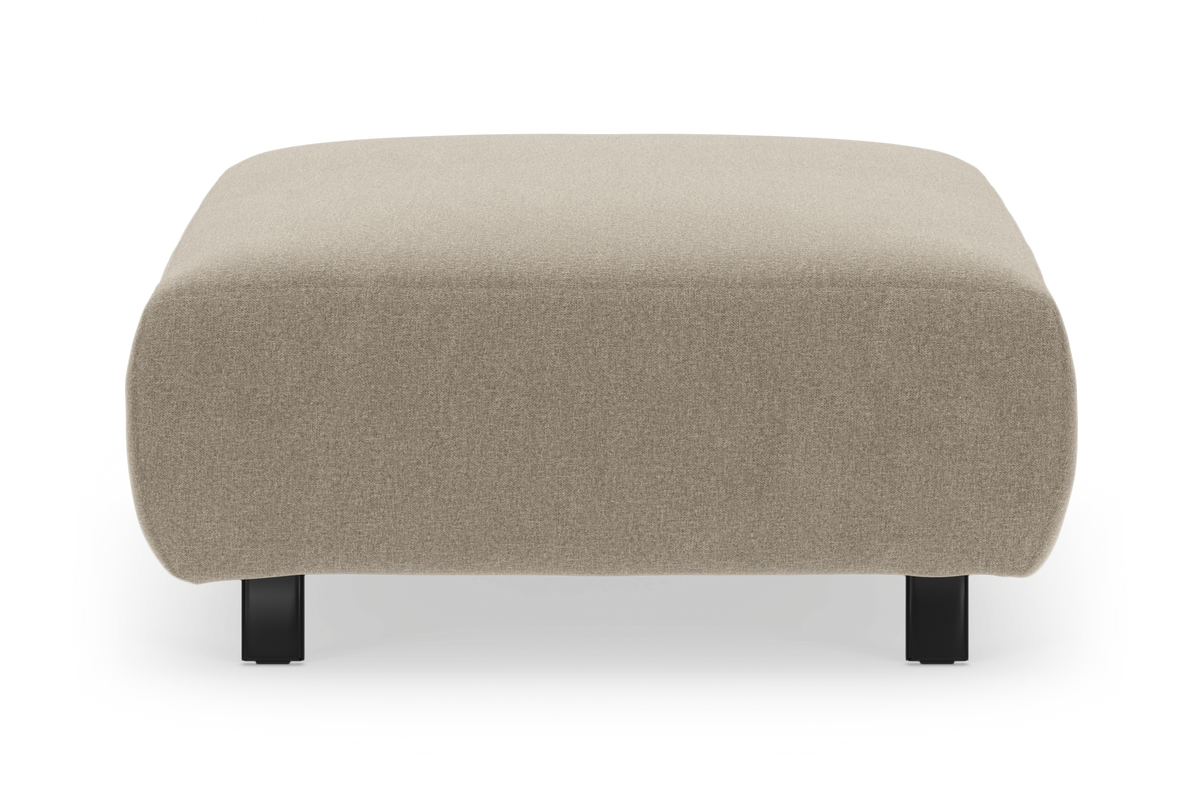 Beige stofpuf/ottoman med afrundede hjørner og sorte ben, set forfra på hvid baggrund.