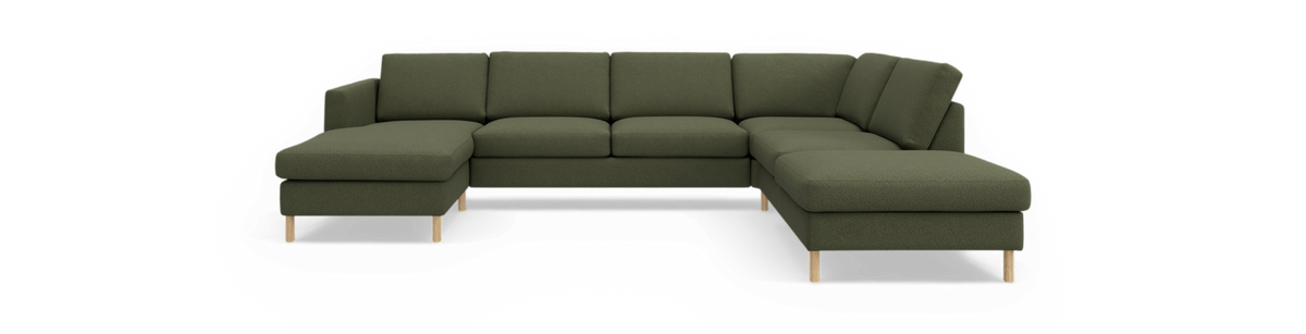 Grøn U-formet modulsofa med chaiselonger i begge ender og træben, frilagt mod sort baggrund.