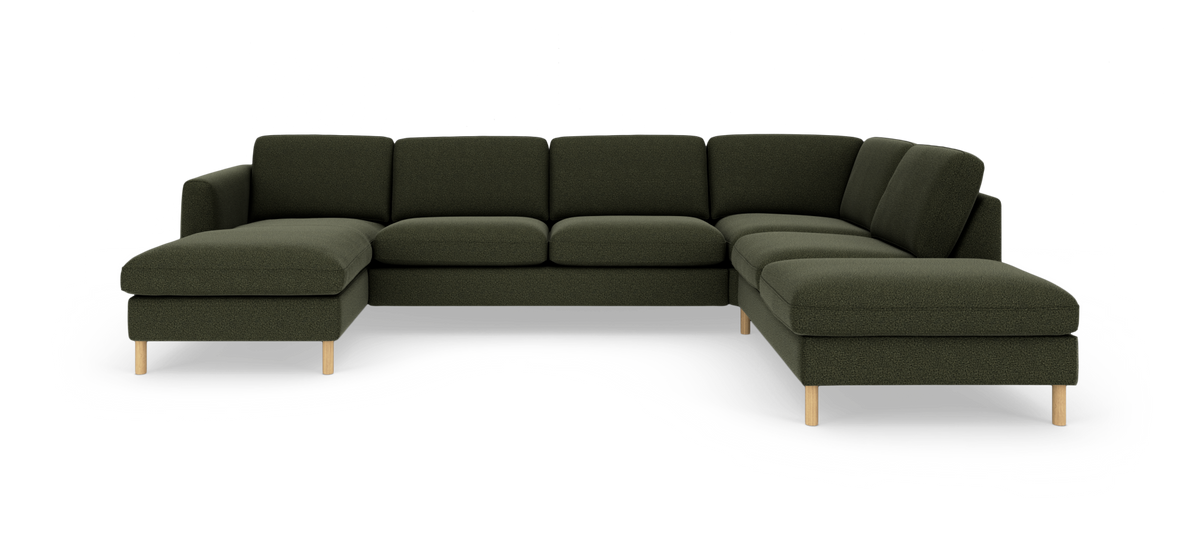 Stor U‑sofa i mørkegrønt stof med chaiselong til venstre og åbent afslut til højre, runde træben.