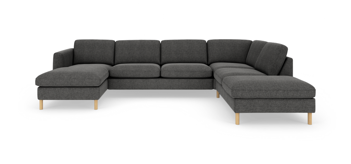 Mørkegrå L‑formet modulsofa med chaiselong til venstre og divan/loungedel til højre, træben, fritlagt på hvid baggrund.