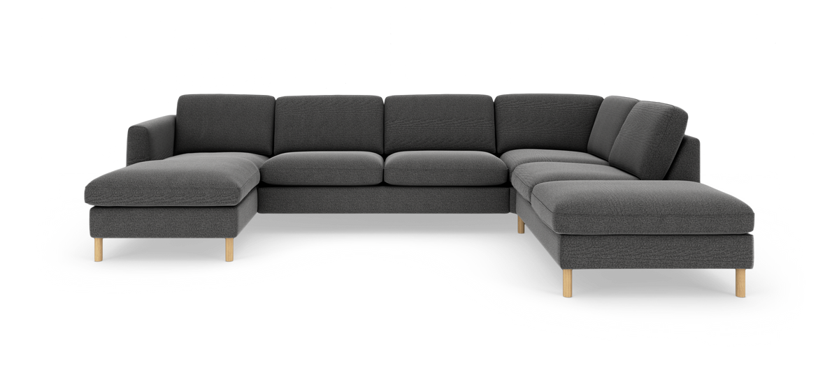 Mørkegrå U-sofa i stof med venstrevendt chaiselong og lyse træben, frilagt på hvid baggrund.