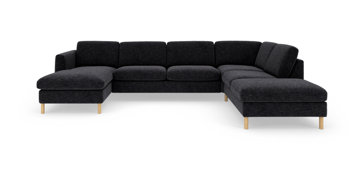 Mørkegrå U-sofa i stof med venstrevendt chaiselong og runde træben, frilagt i studie.