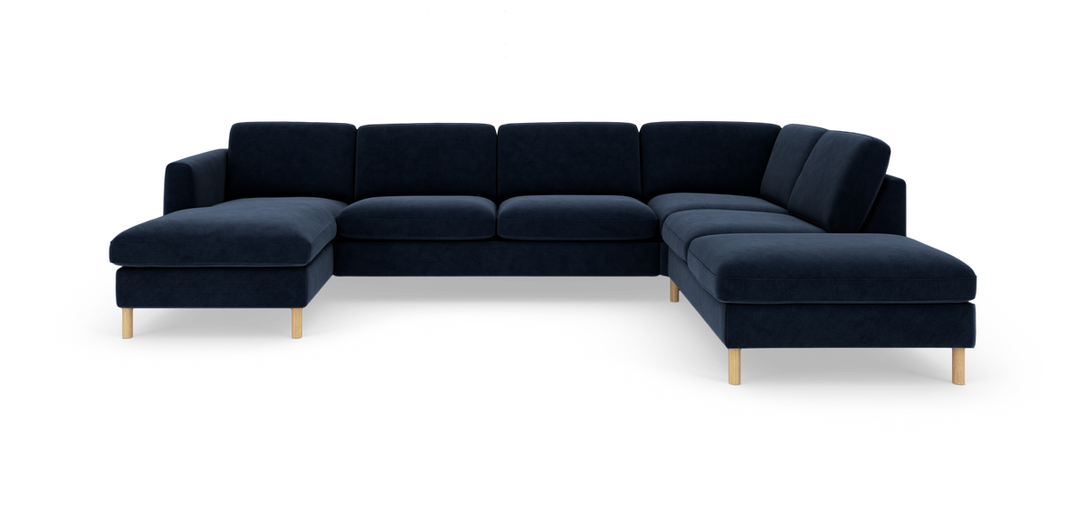 Mørkeblå U‑formet modulsofa med chaiselong og lyse træben, frilagt på hvid baggrund.