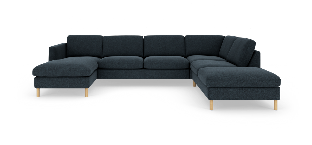 Modulopbygget U-formet sofa i mørk blå tekstil med lyse træben, vist forfra i studieopsætning.
