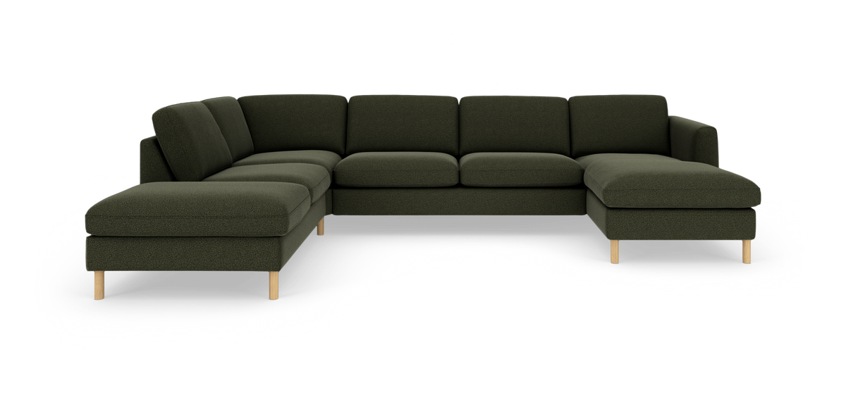 Mørkegrøn modulsofa i U‑form med venstre loungedel og højre chaiselong, runde træben, fritlagt på hvid baggrund.