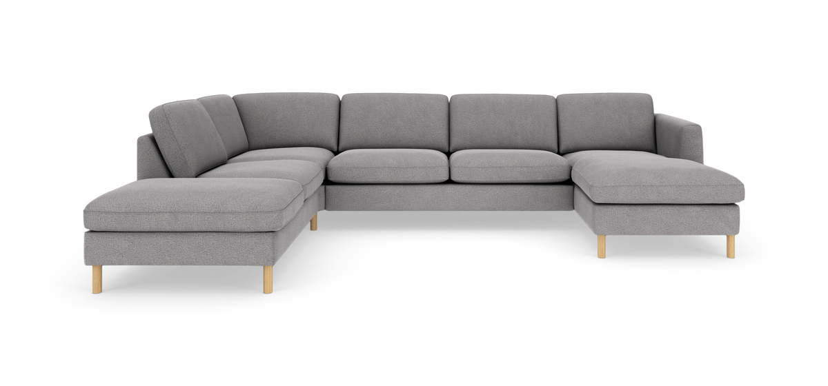 Grå modulsofa i U‑form med chaiselong til højre og træben, frilagt på hvid baggrund.