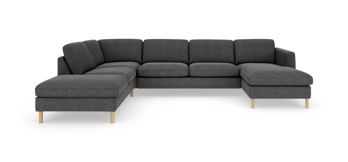 Mørkegrå modulsofa med chaiselong og lyse træben på hvid studiobaggrund.