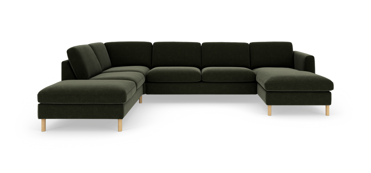 Mørkegrøn modulsofa i U‑form med chaiselonger i begge ender og lyse træben, fotograferet forfra på studiebaggrund.
