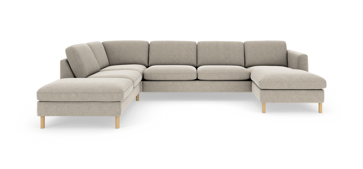 Beige L-formet modulsofa med chaiselong på højre side, lyse træben, frilagt på hvid baggrund.