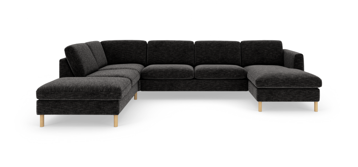 Mørkegrå modulsofa i L‑form med chaiselong, lyse træben, frilagt på hvid baggrund.