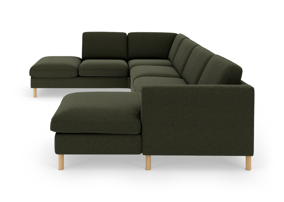Modulær U‑formet hjørnesofa i mørkegrønt stof med to chaiselonger og lyse træben, frilagt på hvid baggrund.