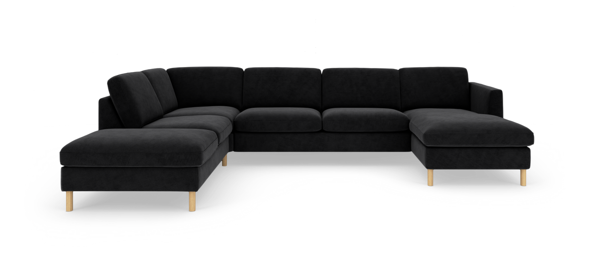 Sort modulsofa i L-form med chaiselong til højre og træben, fritlagt på hvid baggrund.