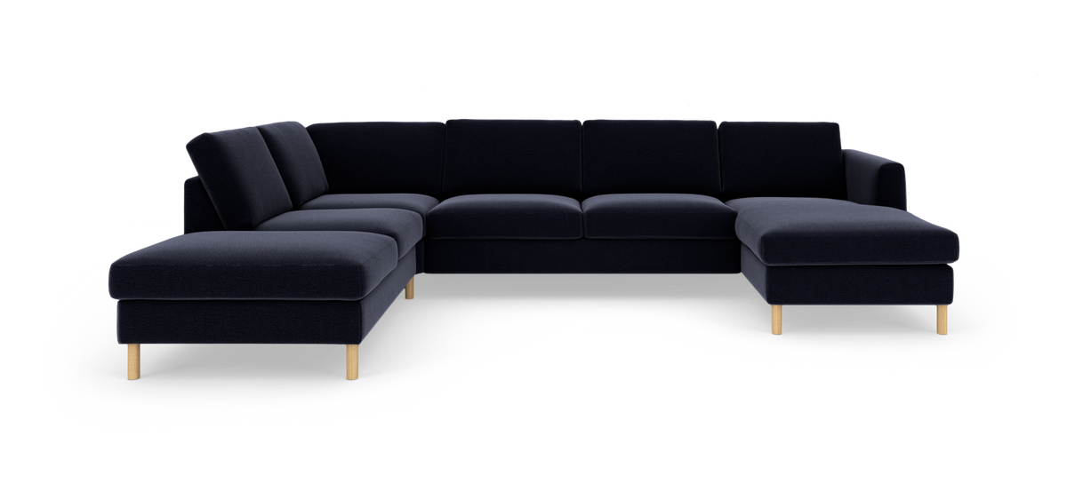 Modulsofa i mørkeblåt stof med U‑form og to chaiselonger, lyse træben.